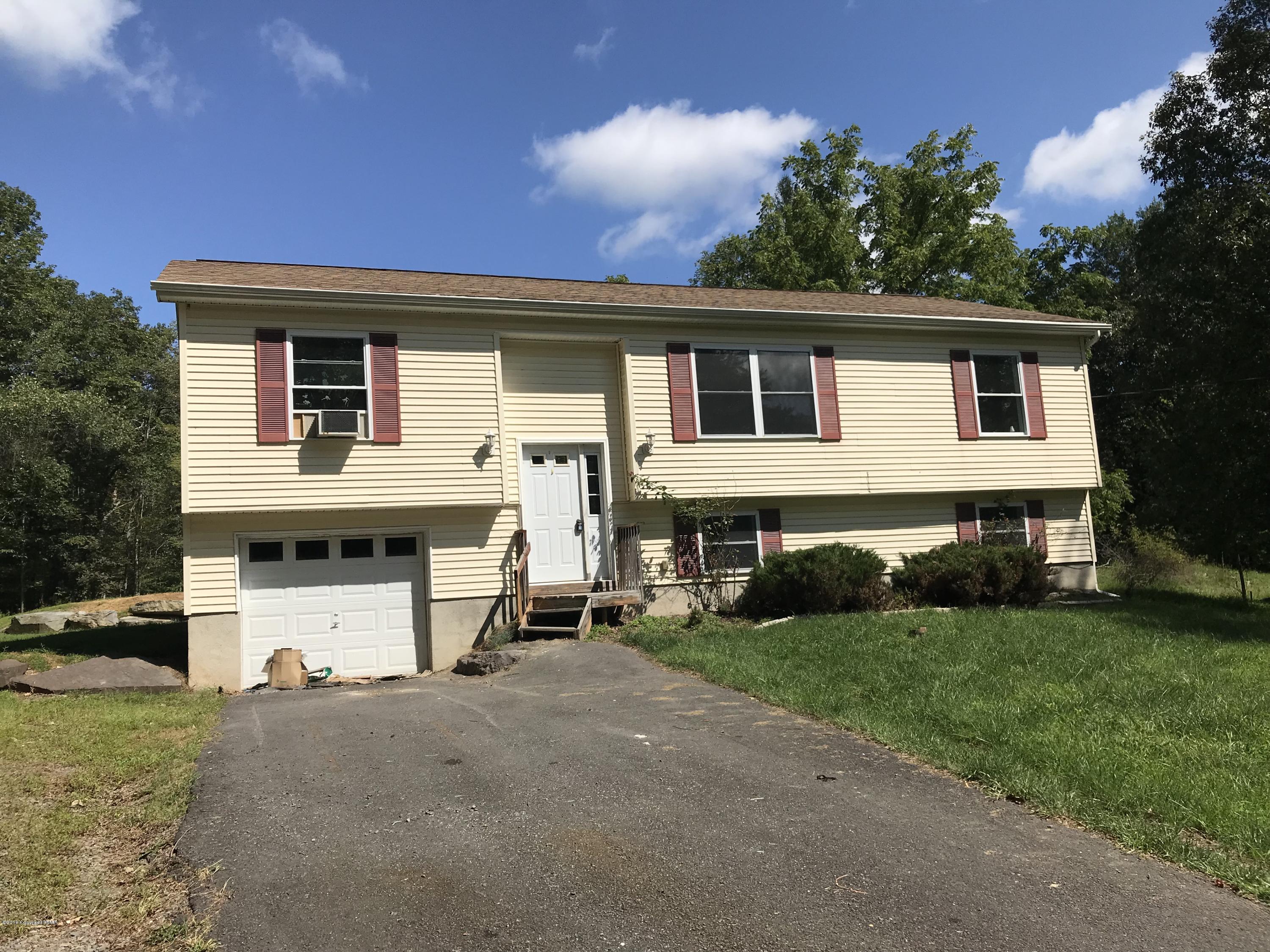 157 Magic Mountain Road Henryville, PA 18332 - Photo 28 of 29 a front view of a house with a yard and garage