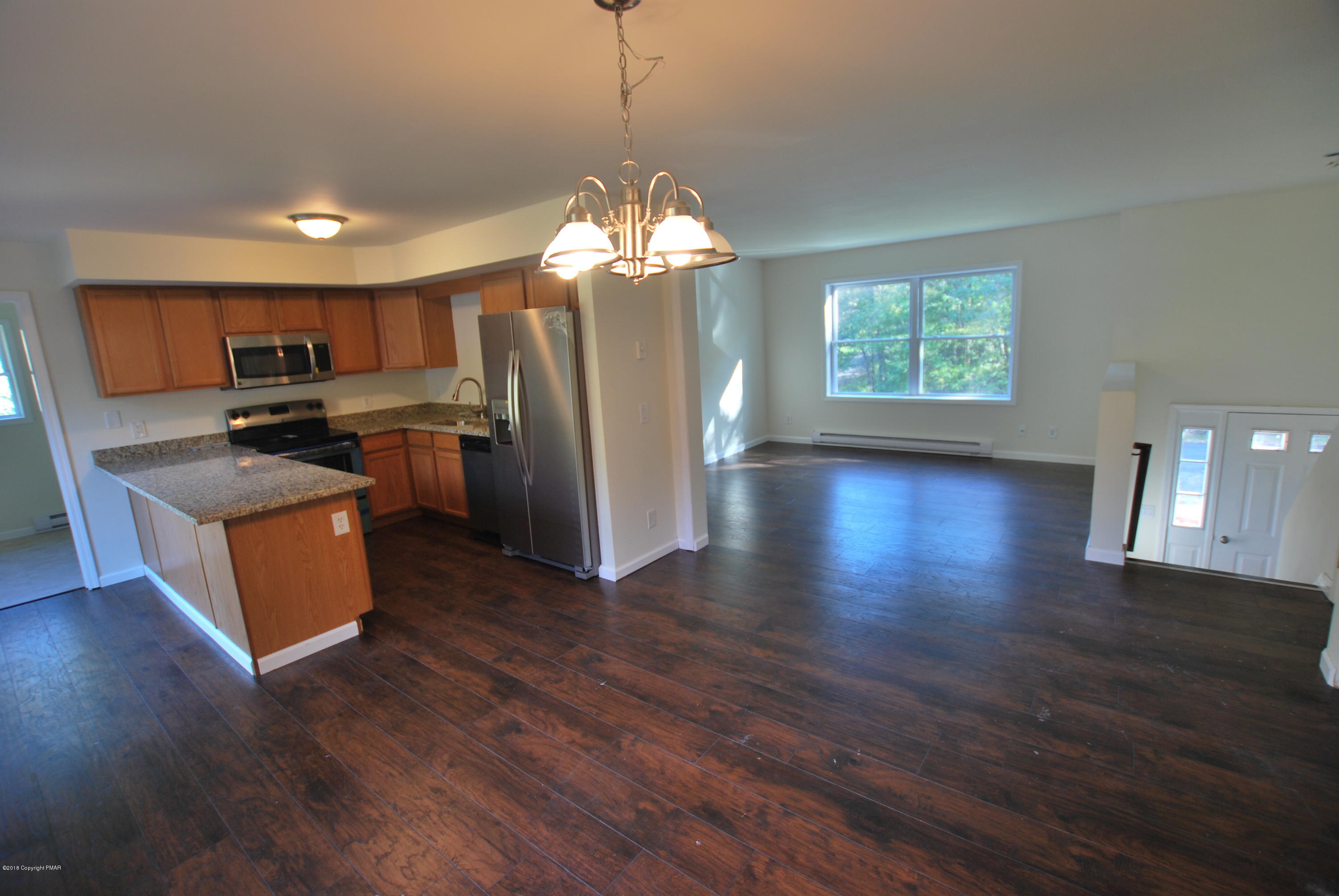 157 Magic Mountain Road Henryville, PA 18332 - Photo 3 of 29 a kitchen with stainless steel appliances granite countertop a refrigerator a stove top oven a sink dishwasher and wooden floor