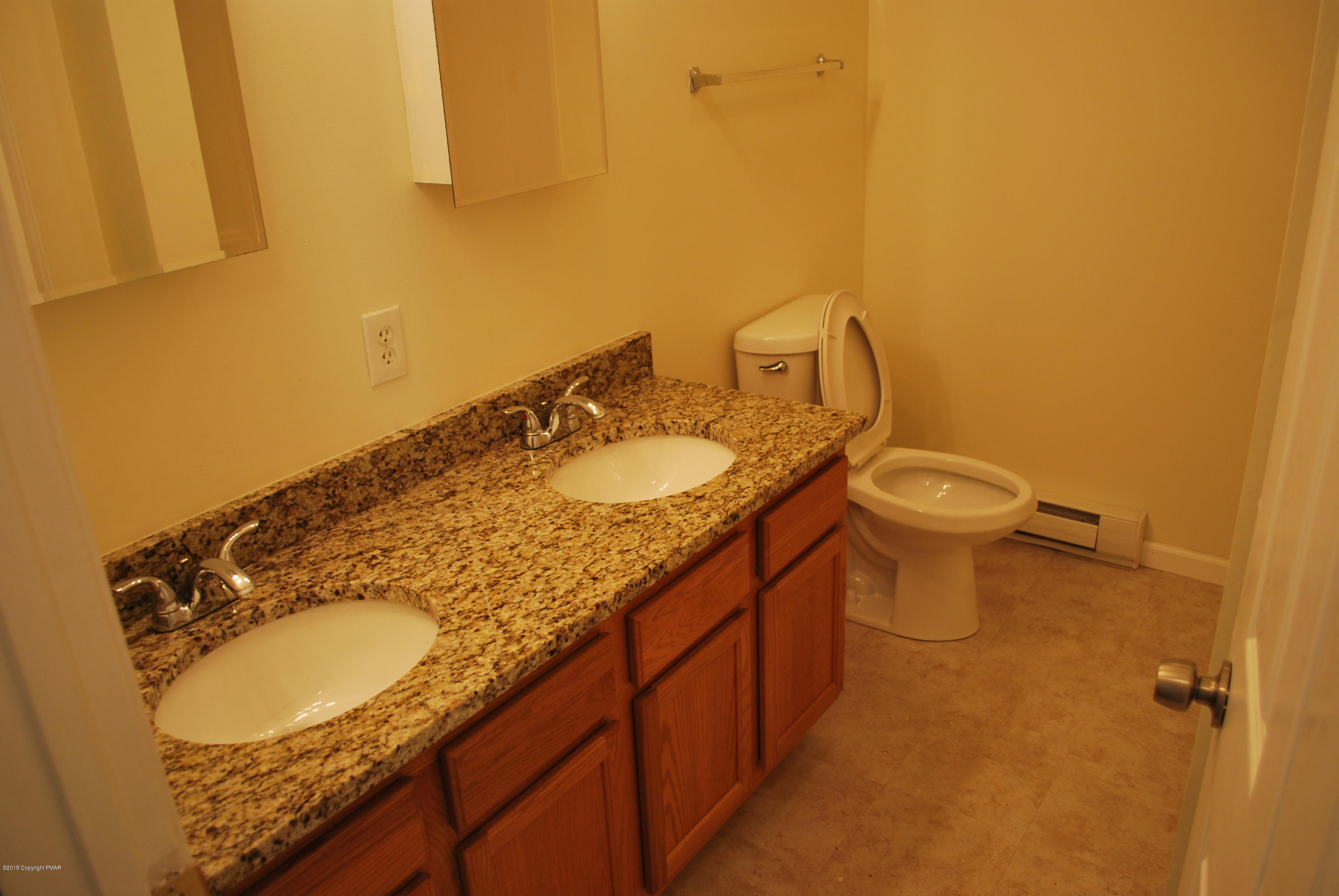 157 Magic Mountain Road Henryville, PA 18332 - Photo 5 of 29 a bathroom with a granite countertop sink a toilet and a mirror