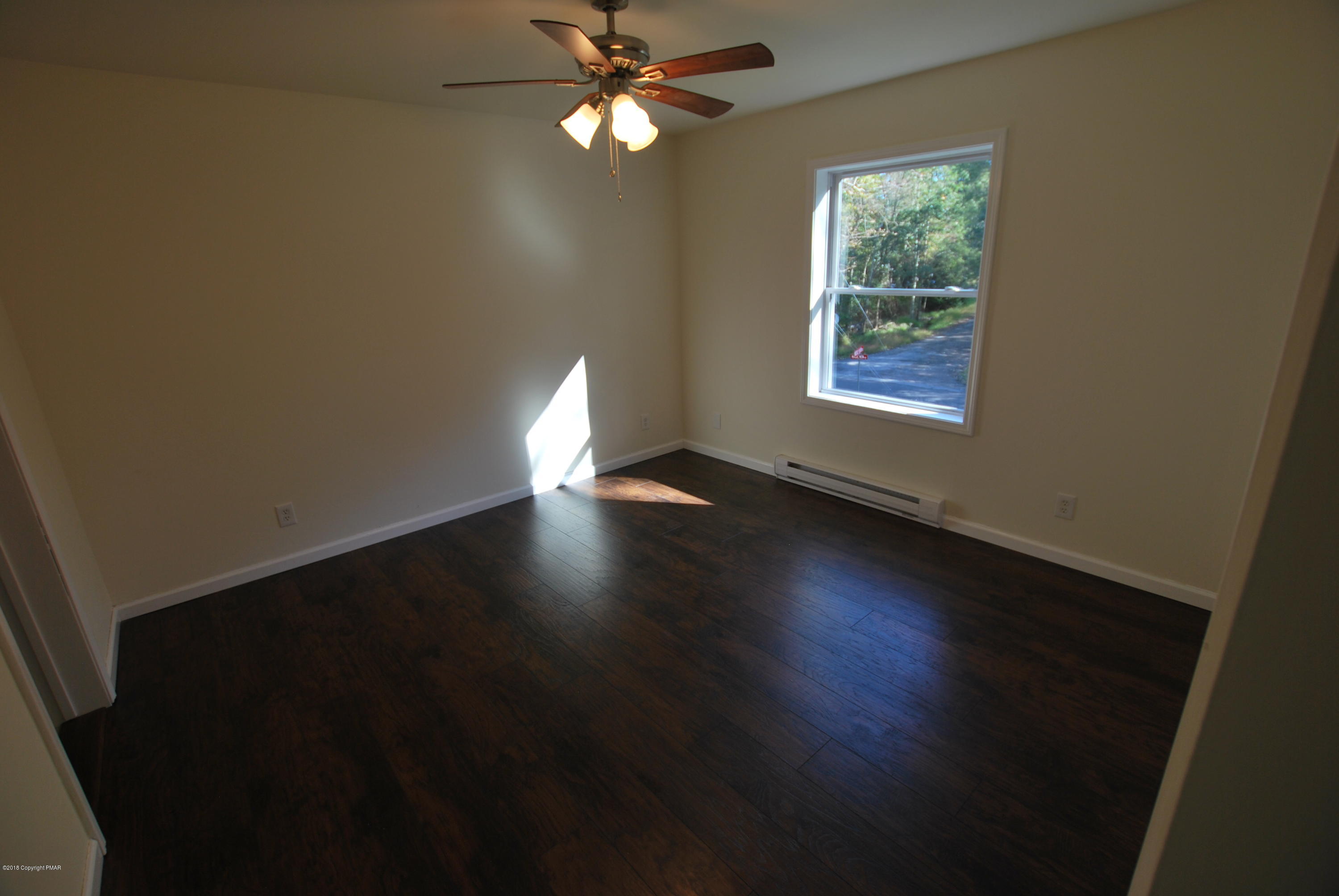 157 Magic Mountain Road Henryville, PA 18332 - Photo 8 of 29 wooden floor in an empty room with a window