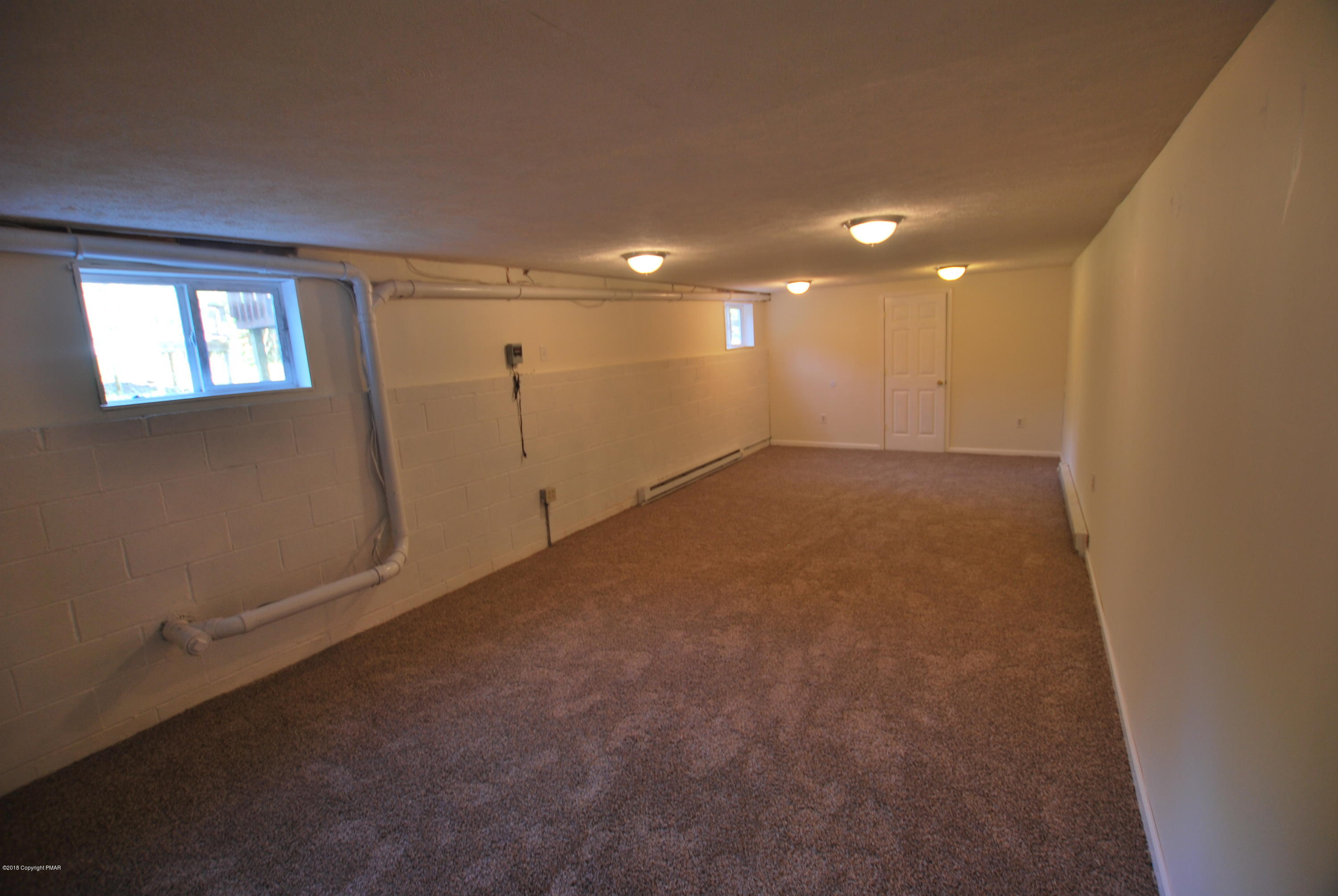 157 Magic Mountain Road Henryville, PA 18332 - Photo 9 of 29 an empty room with a empty space and windows