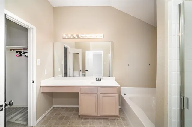 a bathroom with a tub sink and mirror