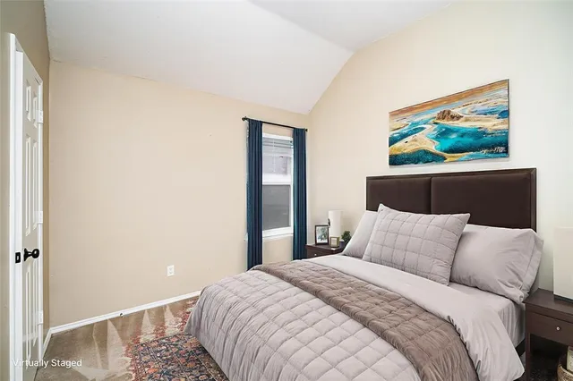 a bedroom with a bed and painting on the wall