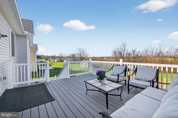 a roof deck with couches and wooden floor