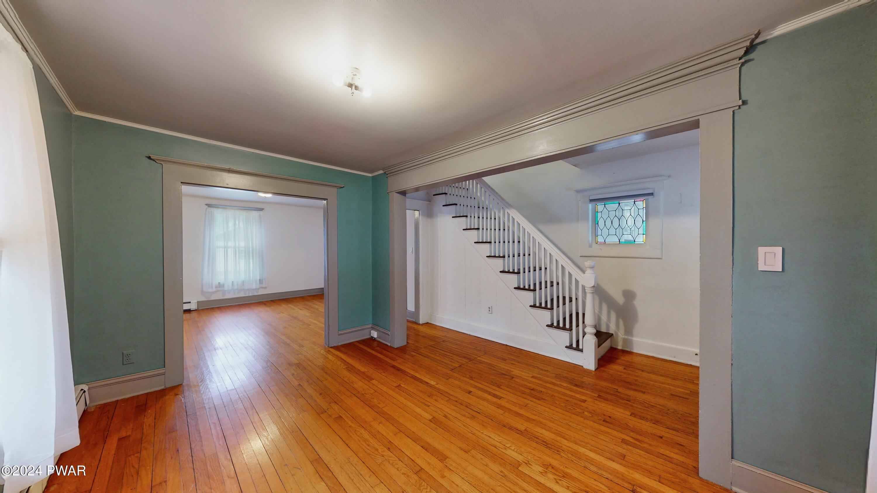 108 9th Street Milford, PA 18337 - Photo 6 of 38 a view of a hallway with wooden floor and stairs