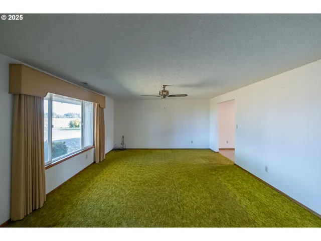 a view of a big room with wooden floor and windows
