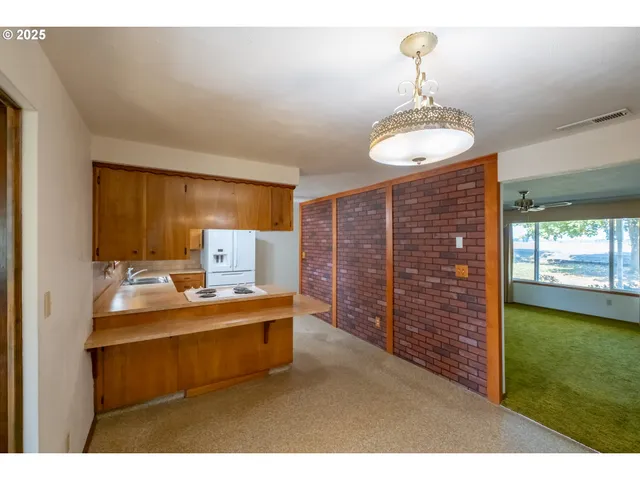 a living room with stainless steel appliances kitchen island granite countertop furniture and a fireplace
