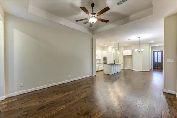 a view of a big room with wooden floor and a kitchen