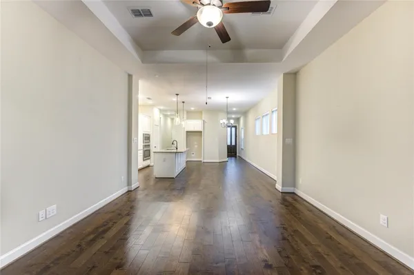 a large kitchen with granite countertop a large kitchen island white cabinetry and stainless steel appliances
