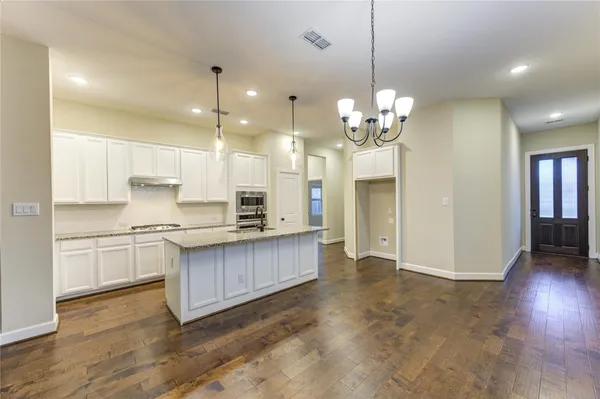 an empty room with wooden floor and ceiling fan
