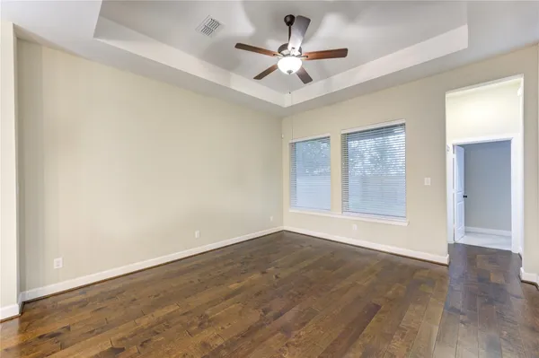 an empty room with a window and a fan