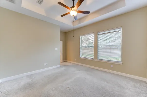 an empty room with a window and a fan