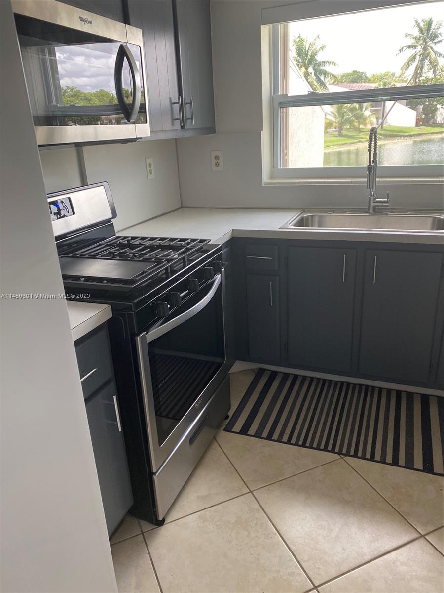 7262 Jacaranda Lane, Unit 7262 Miami Lakes, FL 33014 - Photo 6 of 9 a kitchen with a stove and a sink