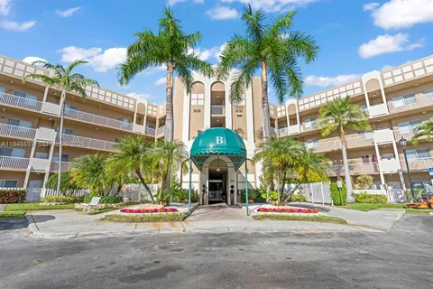 a front view of a building with palm trees