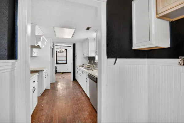 a hallway with cabinets a wooden floor and a fireplace