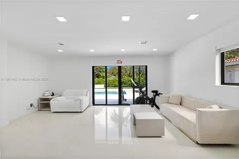 a view of swimming pool with outdoor seating and palm tree