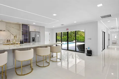a large white kitchen with lots of counter space and a sink