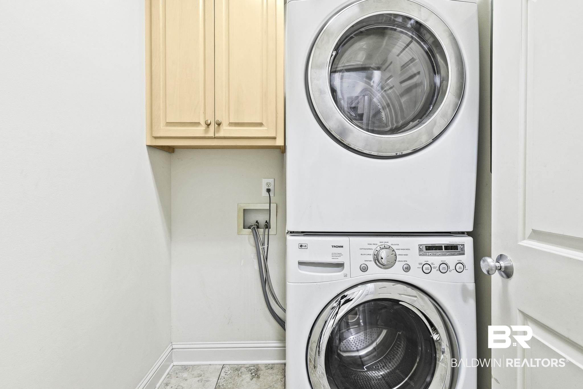 13 Bugle Retreat Daphne, AL 36527 - Photo 21 of 40 Clothes washing area featuring cabinets, light tile patterned floors, and stacked washing maching and dryer