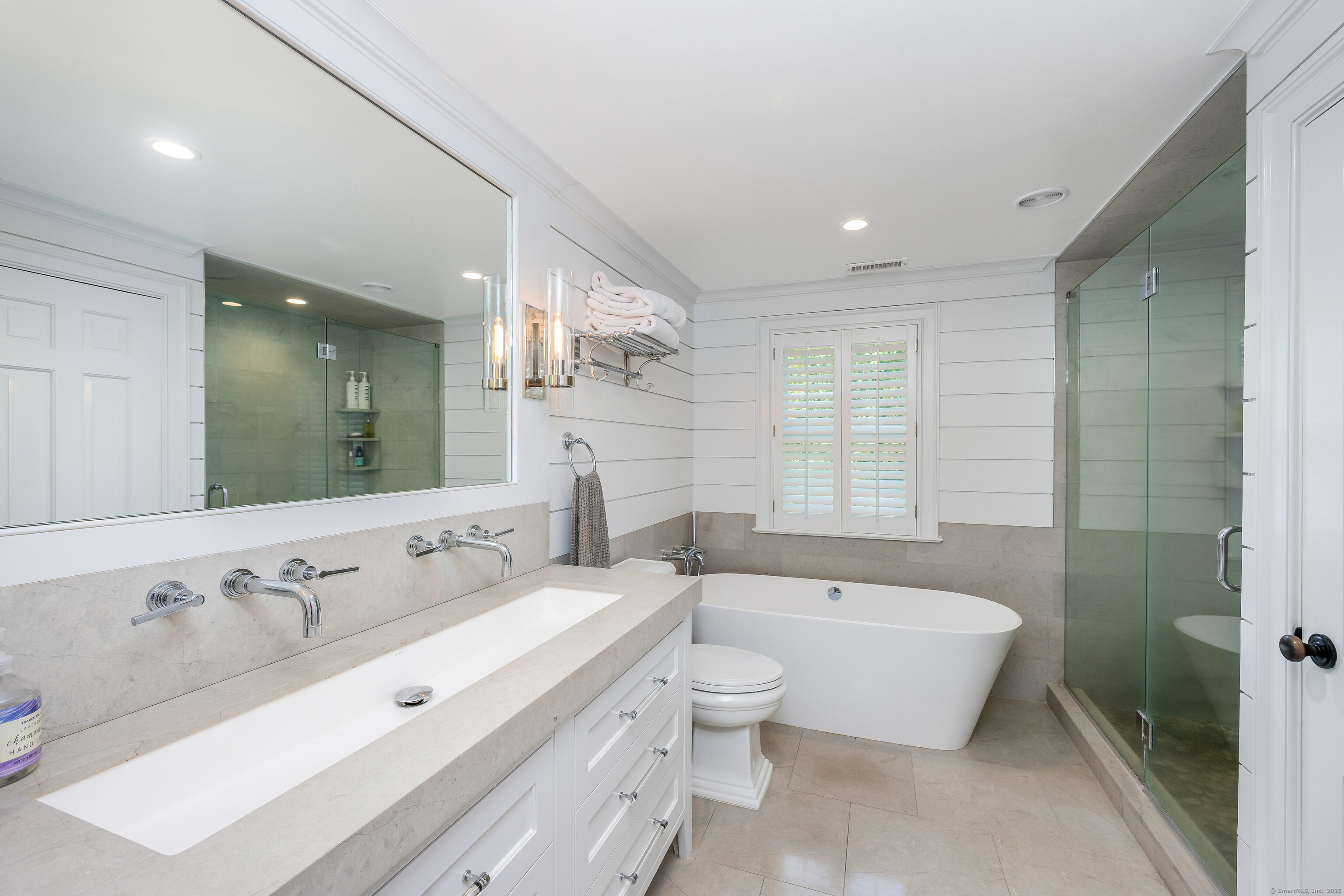 63 Dorchester Road Darien, CT 06820 - Photo 20 of 37 a spacious bathroom with a double vanity sink a mirror and a bathtub