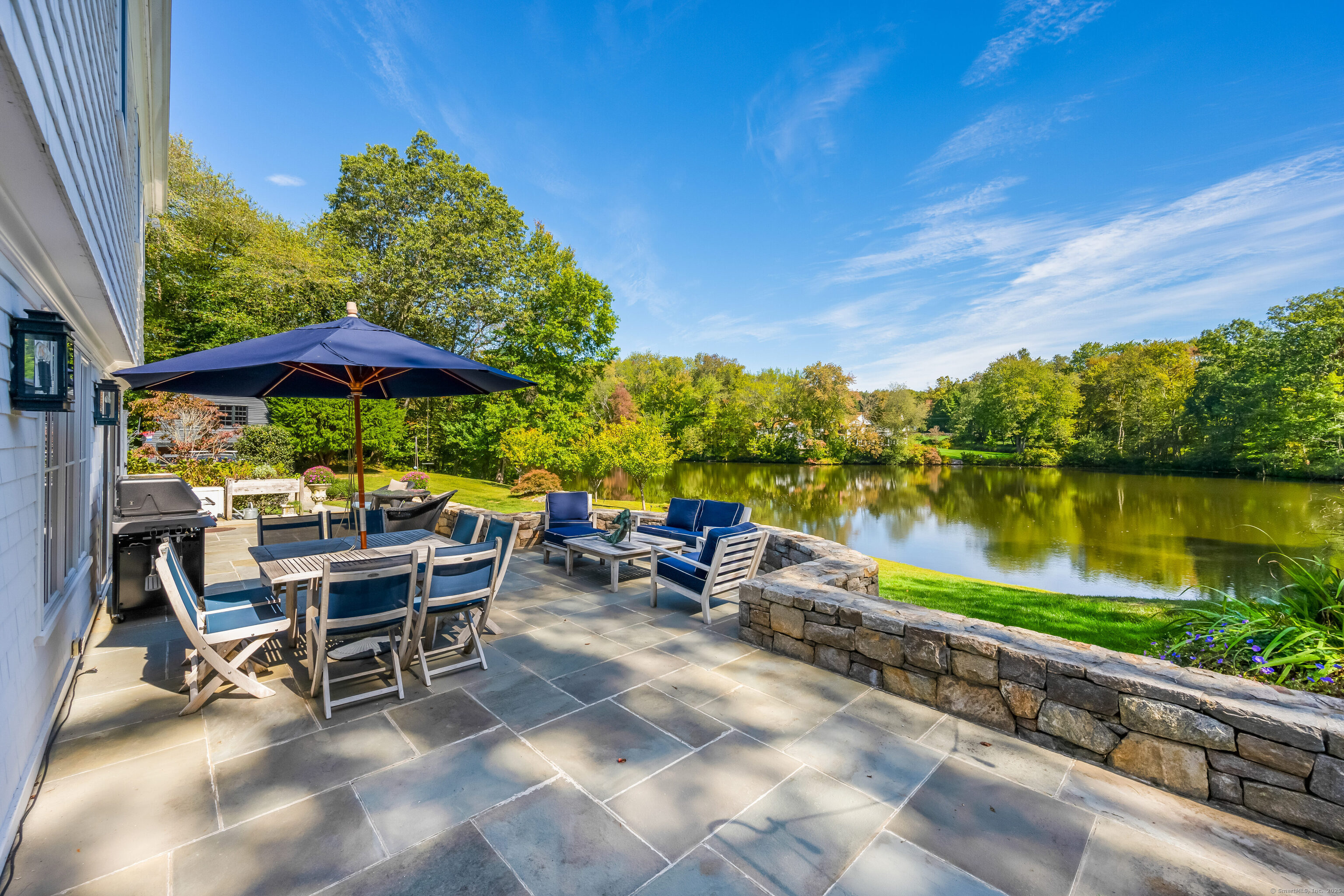 63 Dorchester Road Darien, CT 06820 - Photo 29 of 37 a view of a chairs and table under an umbrella in patio