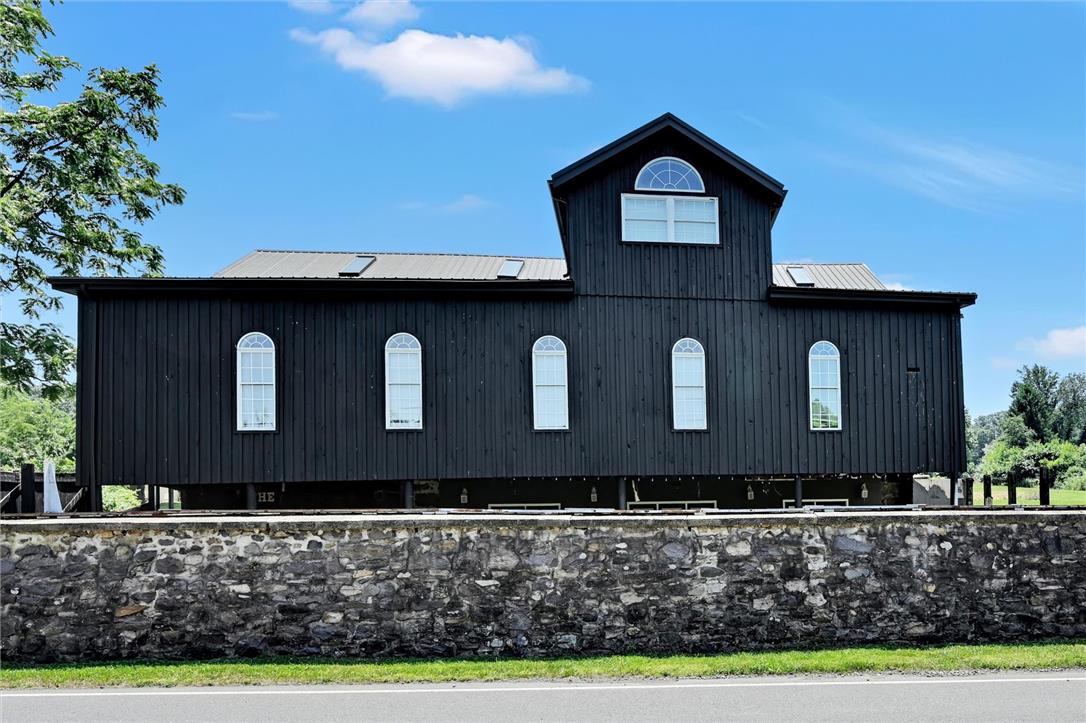 101 Conrad Road Fleetwood, PA 19522 - Photo 40 of 42 Distinctive black barn-style home with classic arched windows and durable metal roofing.