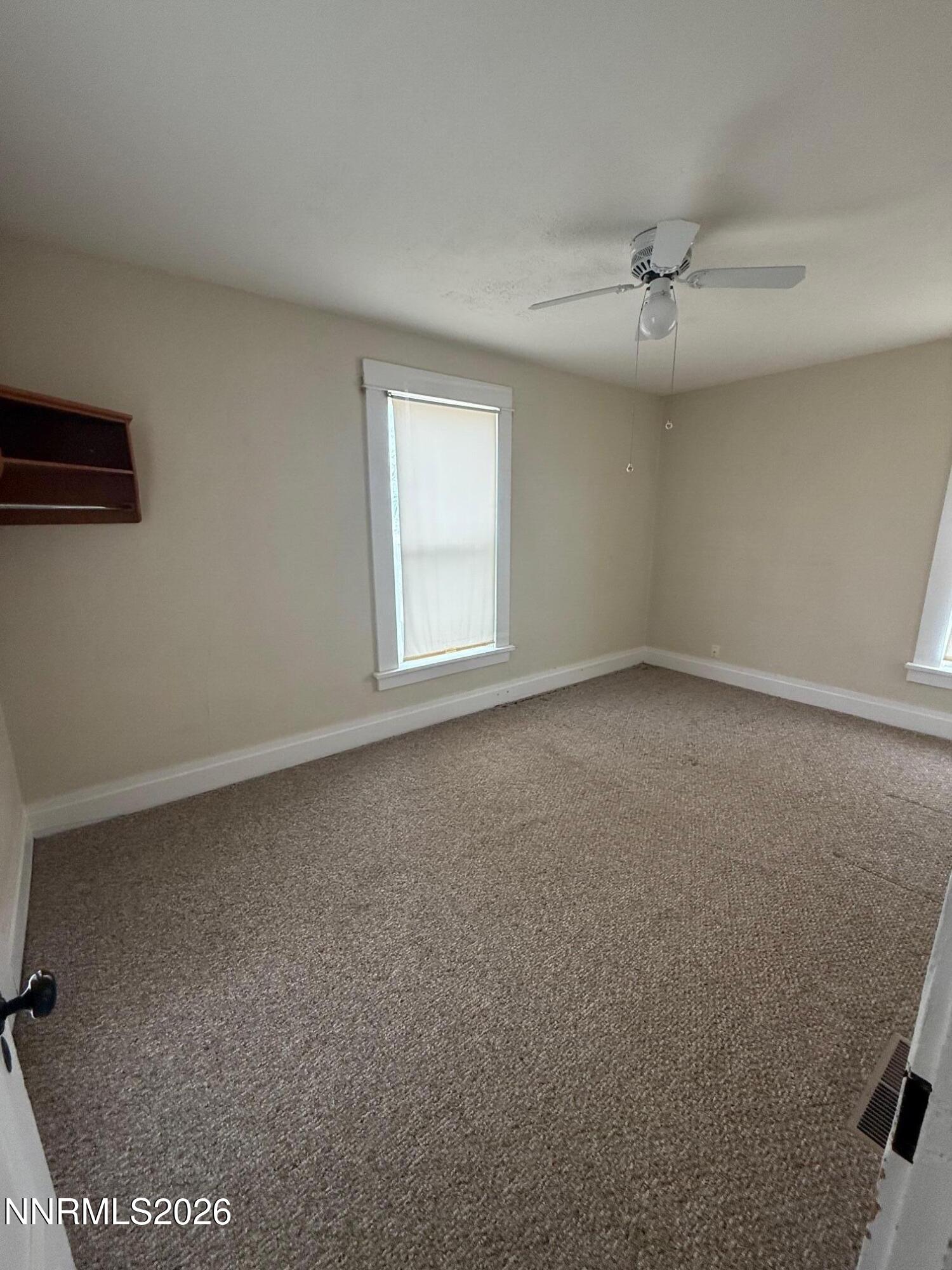 2421 Harrigan Road Fallon, NV 89406 - Photo 13 of 17 an empty room with a ceiling fan and window
