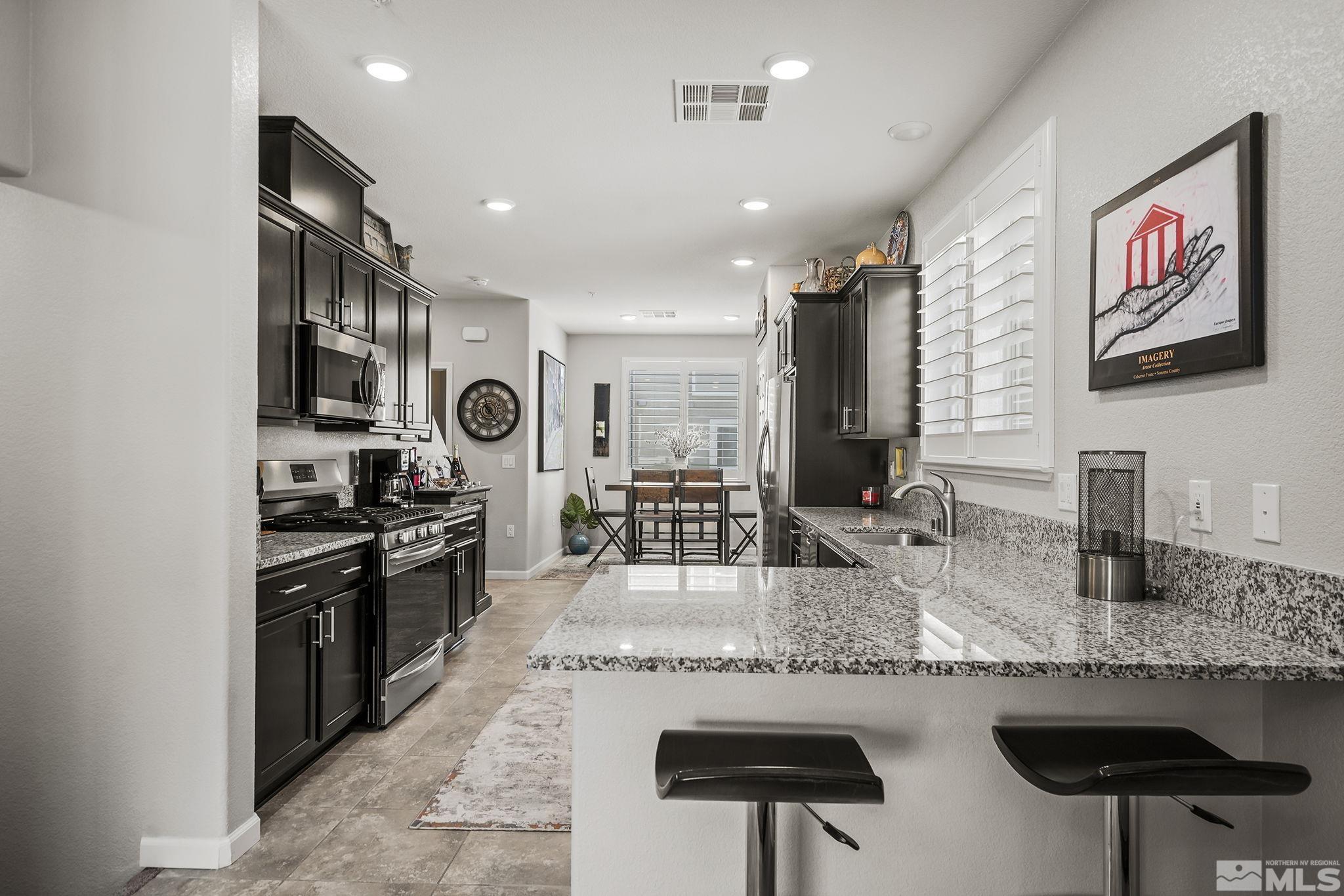 3214 Sterling Ridge Circle Sparks, NV 89431 - Photo 4 of 19 a kitchen with stainless steel appliances granite countertop a stove and a sink