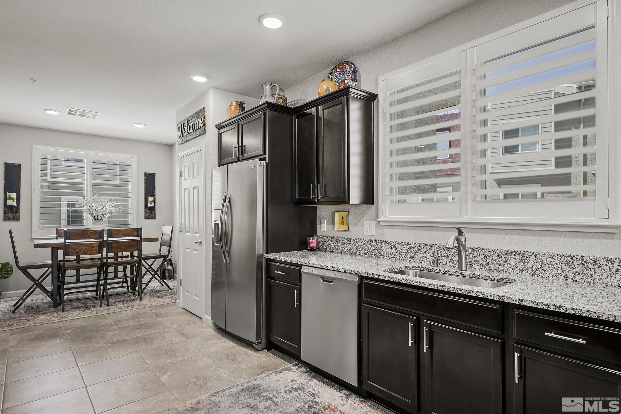 3214 Sterling Ridge Circle Sparks, NV 89431 - Photo 5 of 19 a kitchen with stainless steel appliances granite countertop a sink and a refrigerator