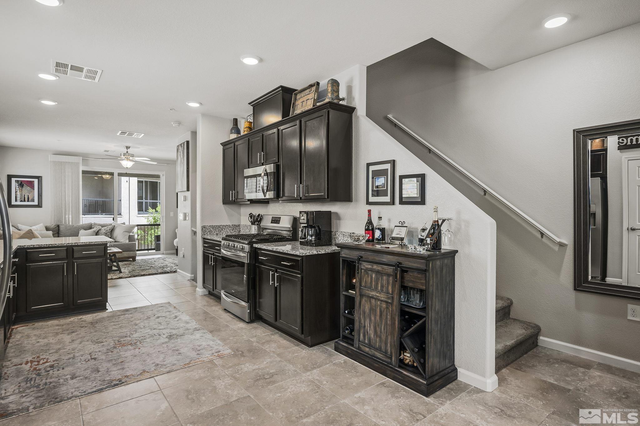 3214 Sterling Ridge Circle Sparks, NV 89431 - Photo 6 of 19 a kitchen with kitchen island granite countertop a stove top oven a sink dishwasher a dining table and chairs with wooden floor