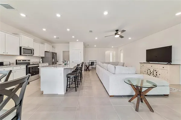 a living room with lots of furniture and kitchen view