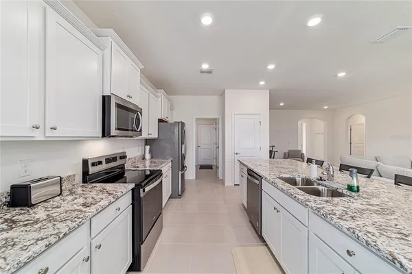 a kitchen with granite countertop a table and chairs in it