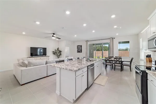 a kitchen with kitchen island sink and living room view