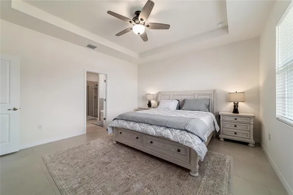 a bedroom with a bed and a flat tv screen on dresser