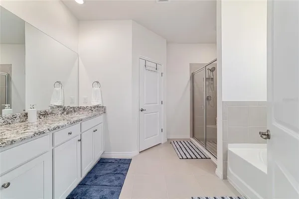 a bathroom with a granite countertop tub a double vanity sink and a mirror