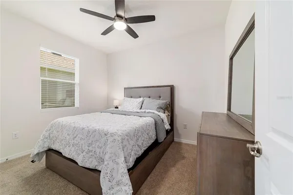 a bedroom with a bed and a chandelier fan