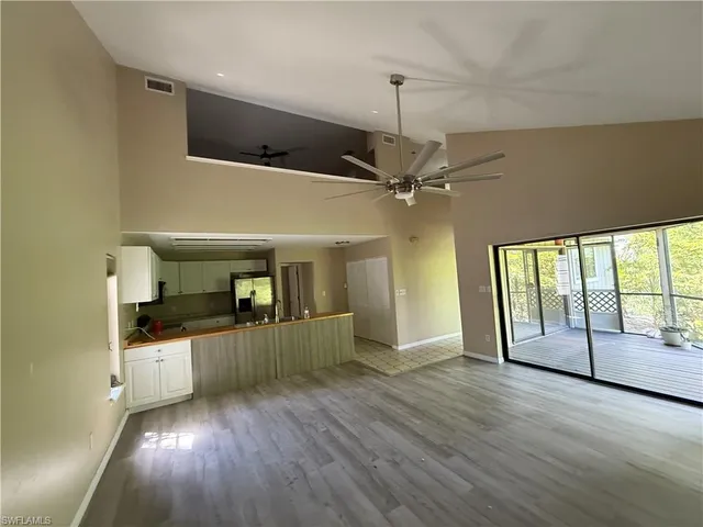 a kitchen view with wooden floor electric appliances and windows