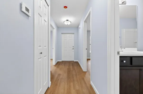 a view of a hallway with wooden floor and staircase