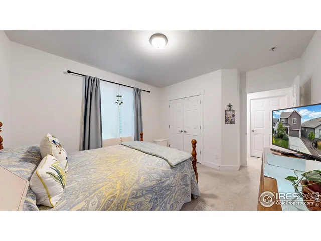 a bedroom with a bed and a flat tv screen on dresser