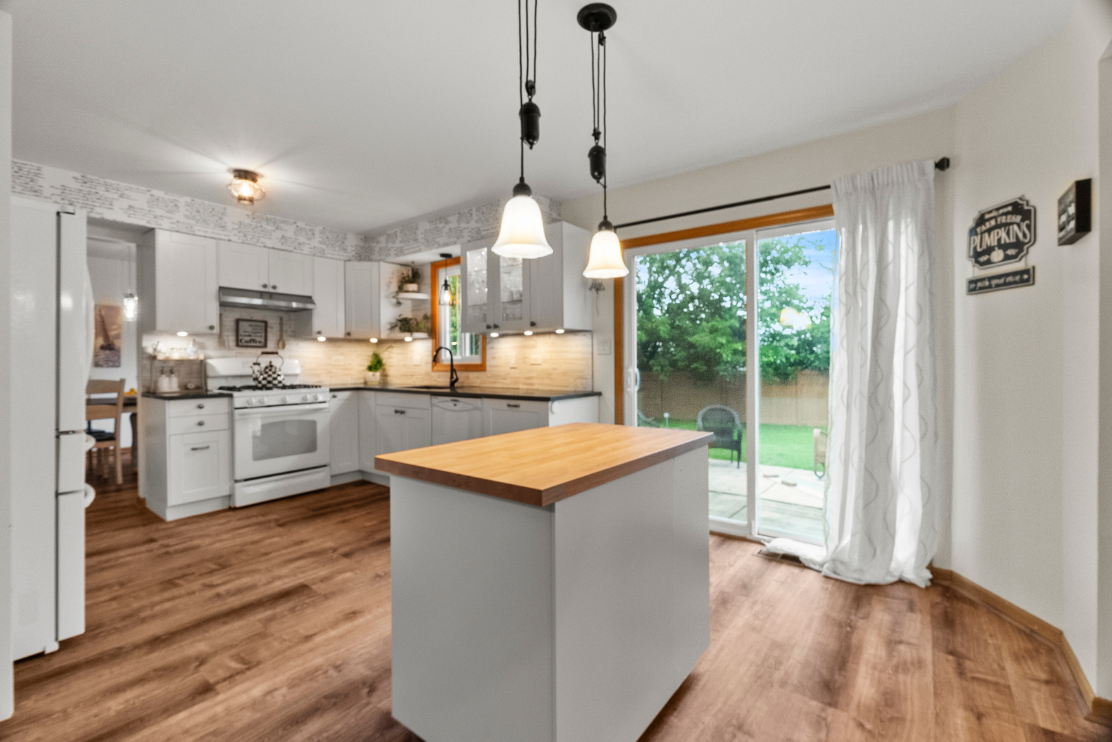 11130 Granite Drive Mokena, IL 60448 - Photo 5 of 41 a kitchen with kitchen island a stove a sink a refrigerator and a wooden floor