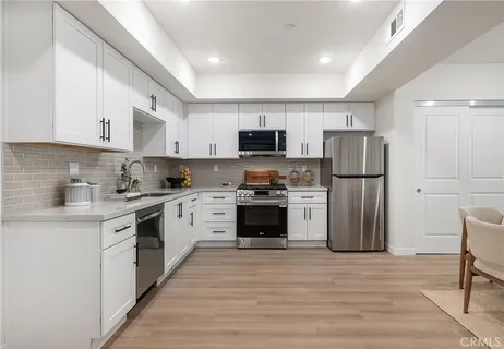 a kitchen with a refrigerator a stove top oven a sink and cabinets