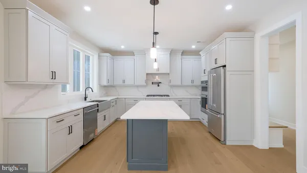 a kitchen with granite countertop white cabinets and refrigerator