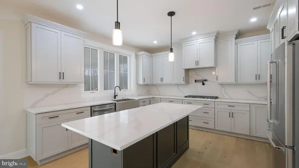 a kitchen with stainless steel appliances granite countertop a sink a center island and cabinets