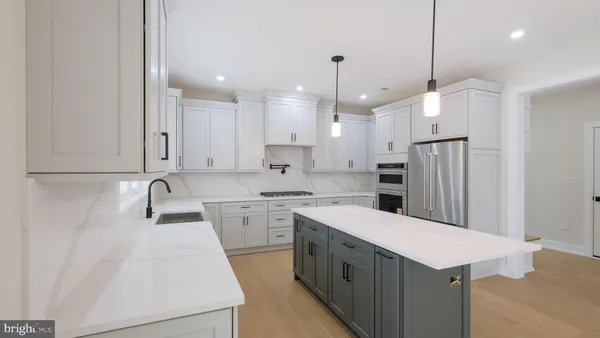 a kitchen with a sink a center island and cabinets