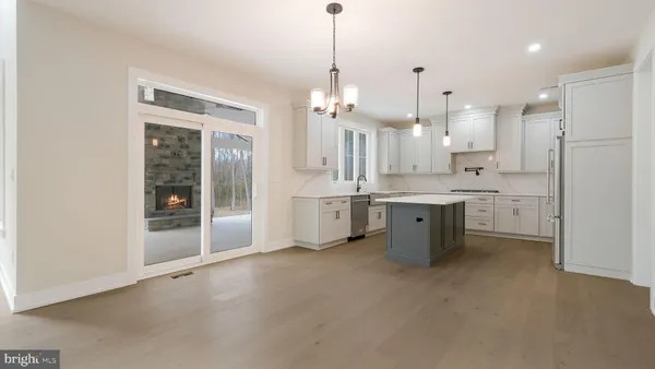 a view of a livingroom with wooden floor and a fireplace
