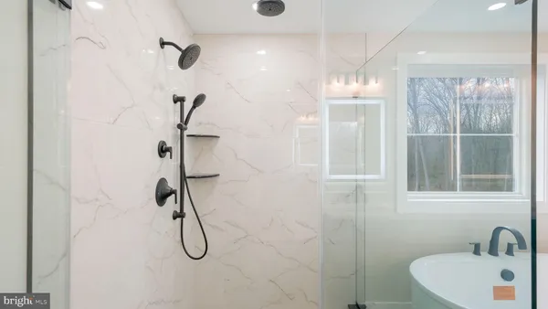 a bathroom with a granite countertop sink a toilet and a window