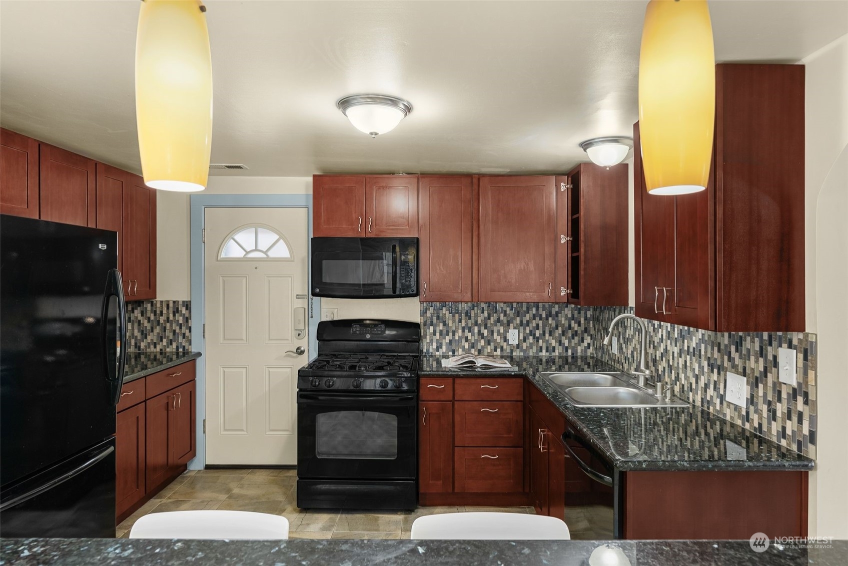 5915 Southwest Admiral Way Seattle, WA 98116 - Photo 15 of 31 a kitchen with stainless steel appliances granite countertop a stove a sink and a microwave