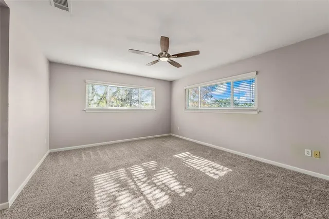 a view of a hallway with wooden floor and a bathroom