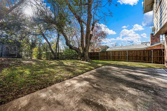 a view of a yard with a house and a large tree