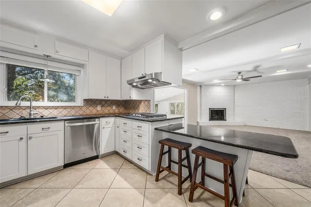 a kitchen with stainless steel appliances granite countertop a stove a refrigerator and a sink