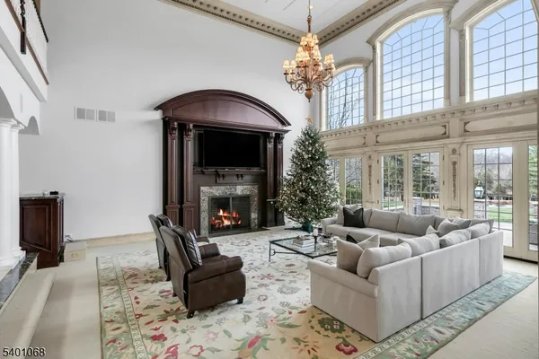 a living room with furniture a fireplace and a chandelier